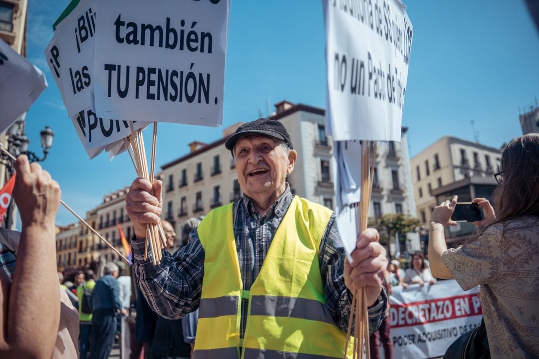 Un manifestante con pancartas durante la manifestación contra las reformas de pensiones llevadas a cabo por el Gobierno en la presente legislatura, a 15 de abril de 2023, en Madrid (España).