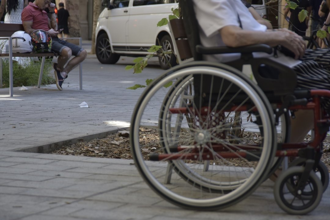 Una persona en silla de ruedas en la calle Consell de Cent, a 8 de septiembre de 2023, en Barcelona, Catalunya (España). (Foto: David Oller / Europa Press)