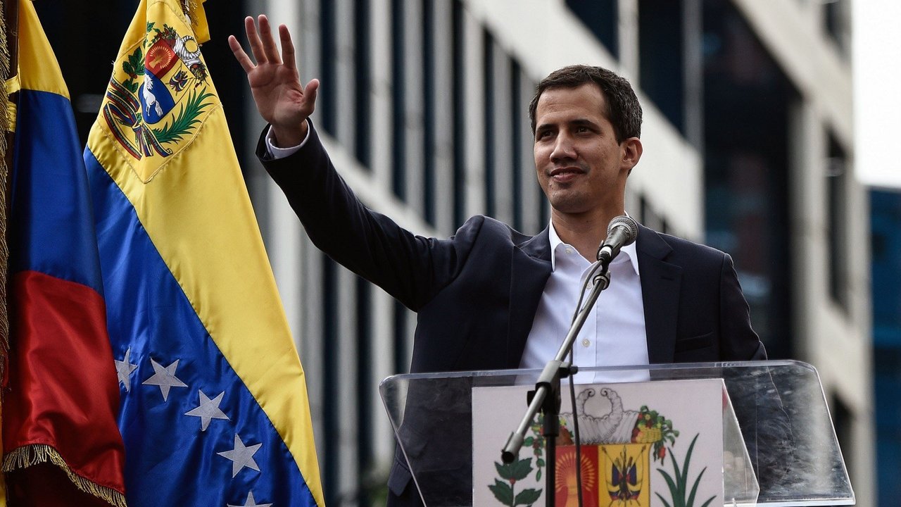 Venezuela's National Assembly head Juan Guaido waves to the crowd during a mass opposition rally against leader Nicolas Maduro in which he declared himself the country's "acting president", on the anniversary of a 1958 uprising that overthrew military dictatorship, in Caracas on January 23, 2019. - "I swear to formally assume the national executive powers as acting president of Venezuela to end the usurpation, (install) a transitional government and hold free elections," said Guaido as thousands of supporters cheered. Moments earlier, the loyalist-dominated Supreme Court ordered a criminal investigation of the opposition-controlled legislature. (Photo by Federico PARRA / AFP)