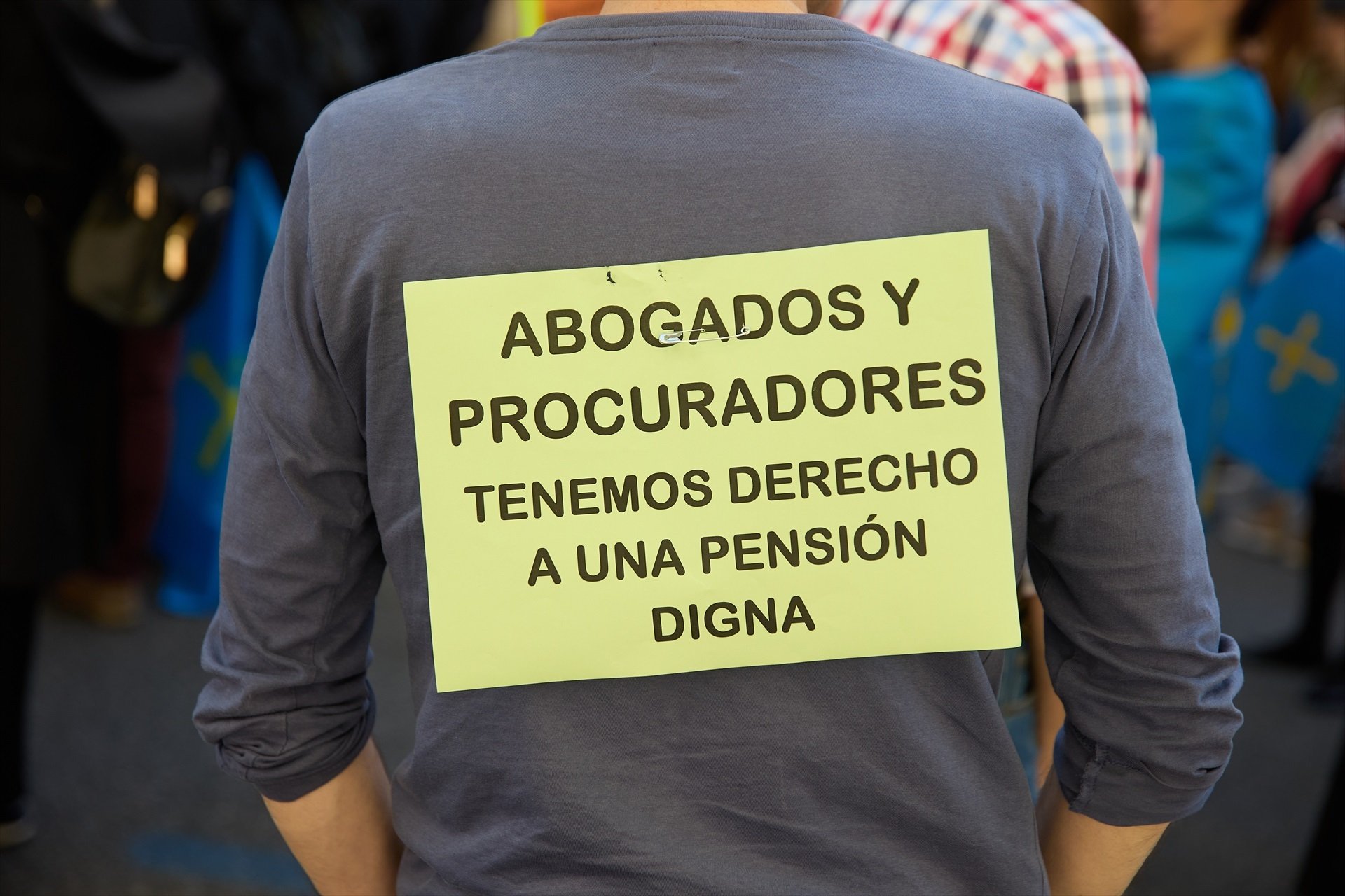 Un hombre con un cartel durante una manifestación contra la ministra de Inclusión, Seguridad Social y Migraciones, frente al colegio de la Abogacía de Madrid, a 13 de abril de 2024 (Foto:  Jesús Hellín / Europa Press)